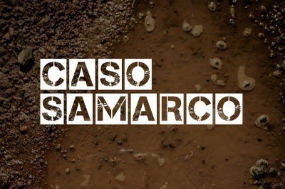 Arte com fundo marrom imitando lama e a expressão Caso Samarco escrita no centro com letras vazadas em quadrados brancos