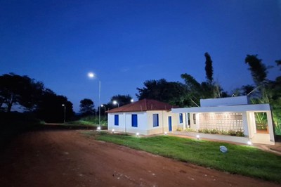 Esta imagem captura a Estação Sobradinho durante o anoitecer, destacando o projeto de iluminação que valoriza a restauração do complexo. Diferente das fotos anteriores, esta foca em uma ala lateral ou anexa, apresentando paredes brancas impecáveis com esquadrias em um azul vibrante.