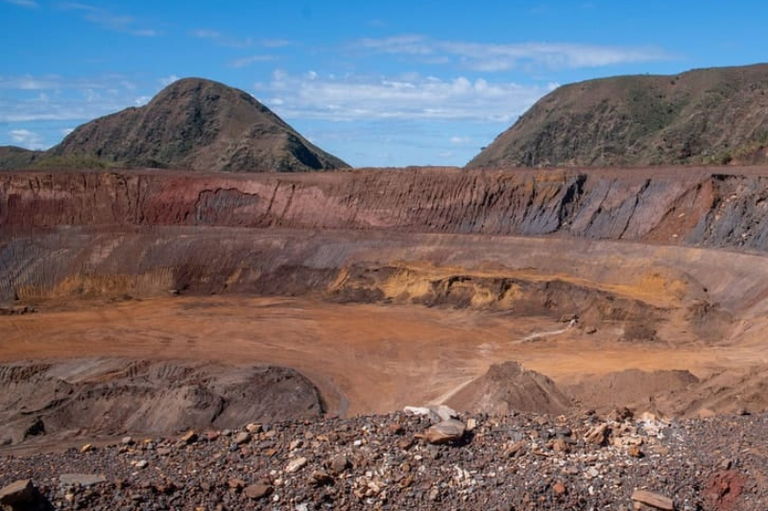 Foto mostra área degradada com escavações no terreno,em área de mineração.