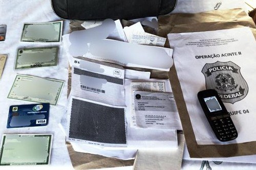 Foto mostra documentos falsificados dispostos em uma mesa