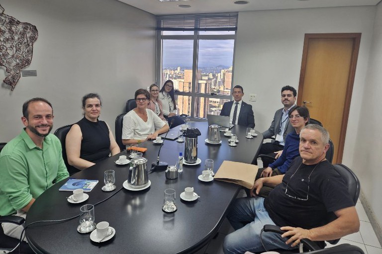 Foto mostra os participantes de uma reunião em volta de uma mesa