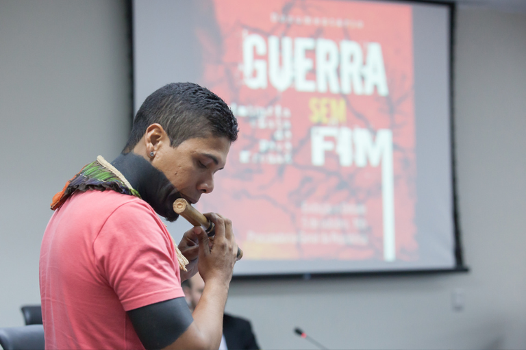Indígena Krenak toca uma flauta típica usada em manifestações culturais do seu povo