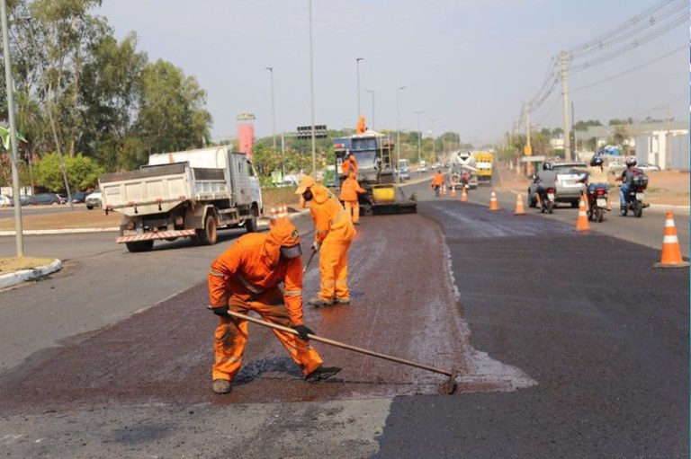 Foto mostra caminhões e trabalhadores fazendo manutenção em um trecho de rodovia