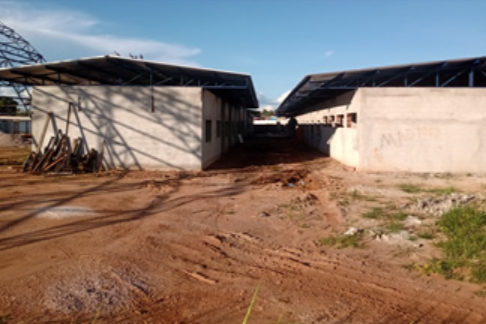 Foto tirada em dia ensolarado mostra a obra de construção de unidade escolar quilombola no município de Vila Bela da Santíssima Trindade. A obra está  passando da fase de alvenaria para a de acabamentos, com aplicação de reboco nas paredes internas e externas.