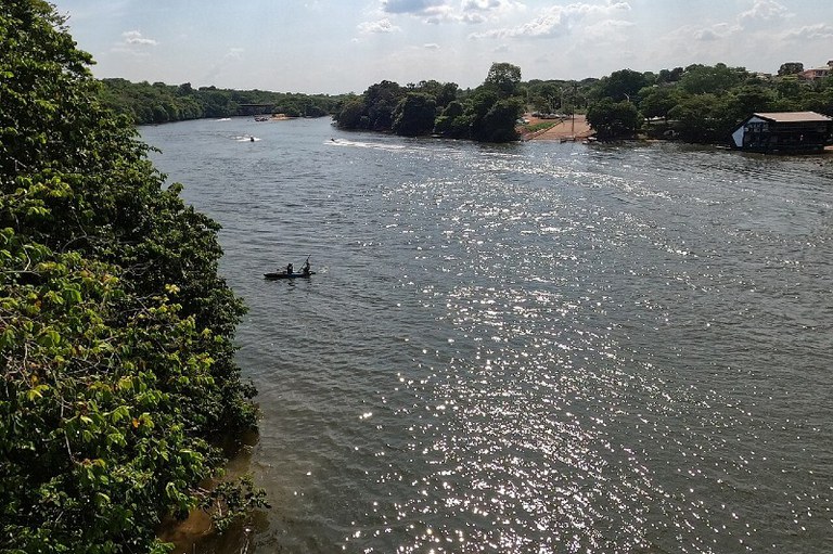 Foto mostra o Rio das Mortes, um curso d'água barrento. Um homem navega de canoa no rio