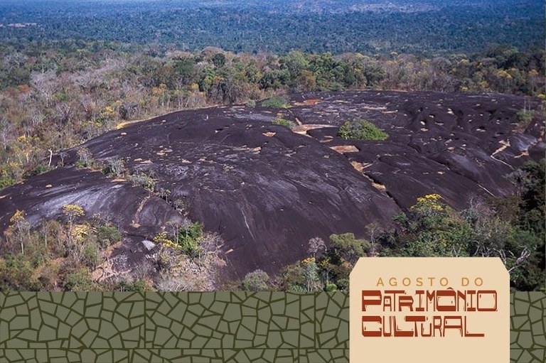 foto mostra a área de um sítio arqueológico em Mato Grosso com vasta vegetação e uma grande pedra