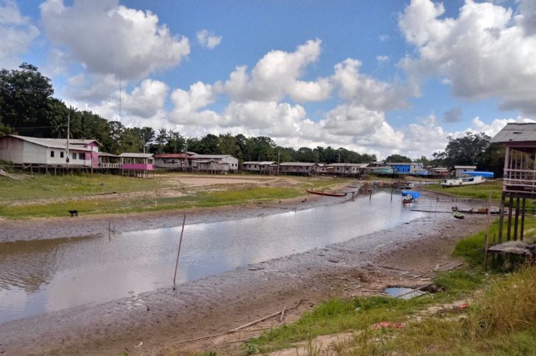 Foto de área de casas na beira de um rio com árvores e mata em volta em um dia de sol na Vila Joviniano Pantoja, no arquipélago do Marajo, Pará.