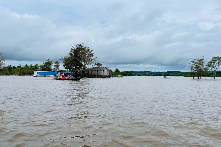 Foto aérea mostra barcos navegando e palafitas ao fundo
