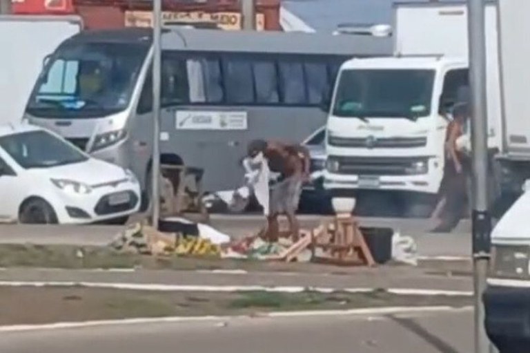 Cena do vídeo apresentado à Justiça, em que pessoa em situação de rua recolhe seus pertences rodeada por policiais