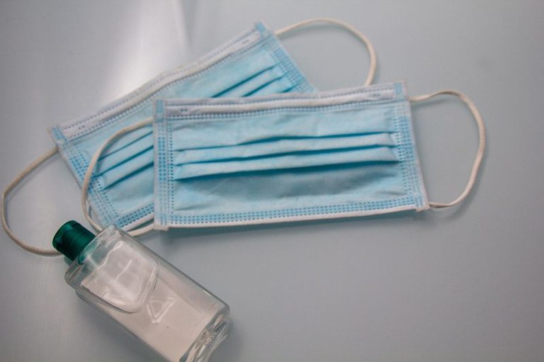 Foto mostra duas máscaras cirúrgicas e um fraco transparente
