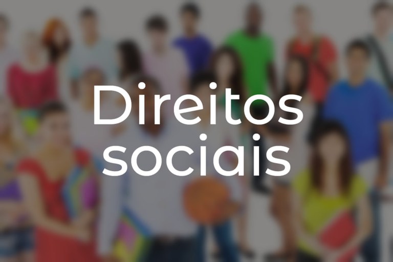 Foto borrada e escurecida de grupo de pessoas. Acima, na cor branca, o texto: Direitos sociais.