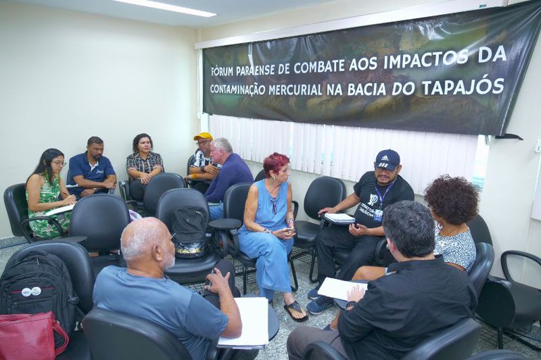 Foto de roda de conversa em sala fechada. Dez pessoas em cadeiras, com banner preto ao fundo: "Fórum Paraense de Combate aos Impactos da Contaminação Mercurial na Bacia do Tapajós".