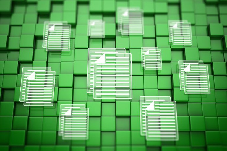 Imagem em perspectiva de um fundo de blocos verdes com ícones translúcidos de documentos brancos flutuando sobre a superfície.