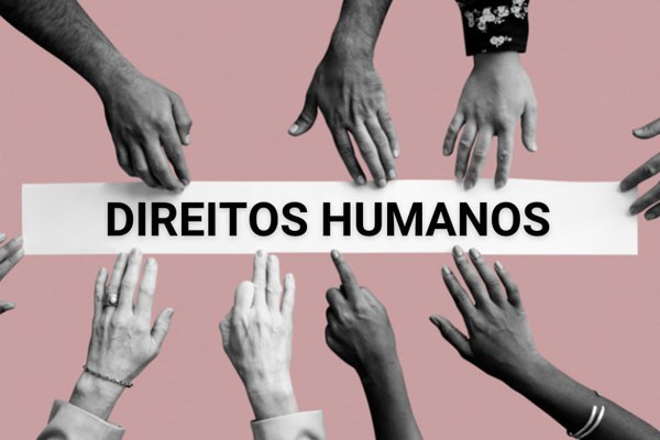 Arte com destaque para o texto Direitos Humanos. O texto está na cor preta, sobre imagem de tira branca de papel. Há fotos em preto e branco de mãos de pessoas que tocam a tira por todos os lados. O fundo é da cor rosa escuro.