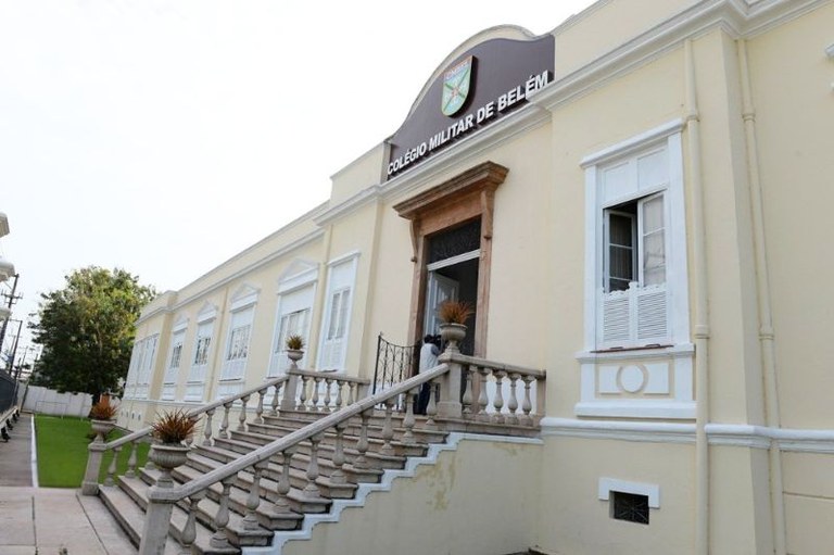 Fachada de prédio claro com escada central de balaustrada e letreiro "Colégio Militar de Belém" no topo.
