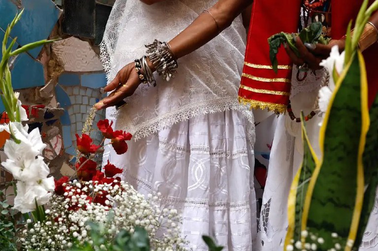 Foto mostra praticantes de religião de matriz africana vestidos de branco e vermelho durante a lavagem da escadaria Baden Powell com água de cheiro homenageia Oxossi, em Copacabana, zona sul da cidade.
