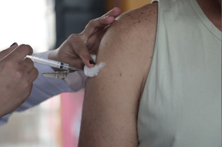 Foto mostra em detalhe uma pessoa sendo vacinada