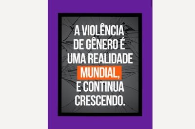 Imagem com fundo de vidro estilhaçado, moldura preta e borda roxa. Ao centro, em letras brancas, lê-se: “A VIOLÊNCIA DE GÊNERO É UMA REALIDADE MUNDIAL, E CONTINUA CRESCENDO.” O visual transmite impacto e urgência.