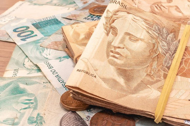 Foto mostra cédulas de 100 e 50 reais e alguma moedas