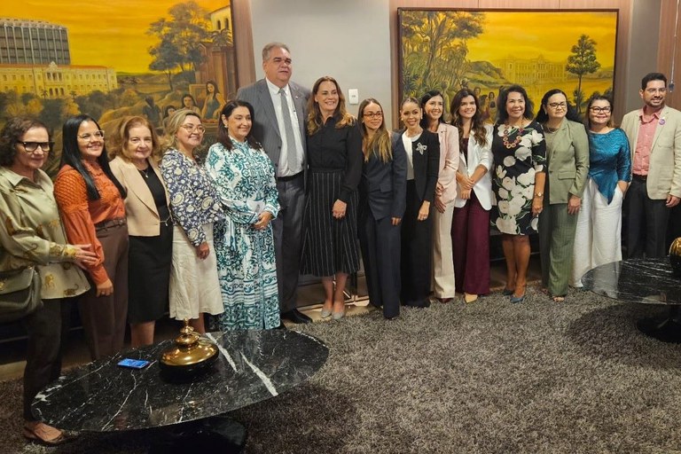Fotografia do presidente do TJPB, Fred Coutinho, ladeado por cinco mulheres, à esquerda, e oito mulheres e um homem, à direita. Todos estão na solenidade de lançamento do Observatório de Violência Doméstica do TJPB, em uma sala do tribunal, com quadros ao fundo, e em pé, olhando para outra câmera.