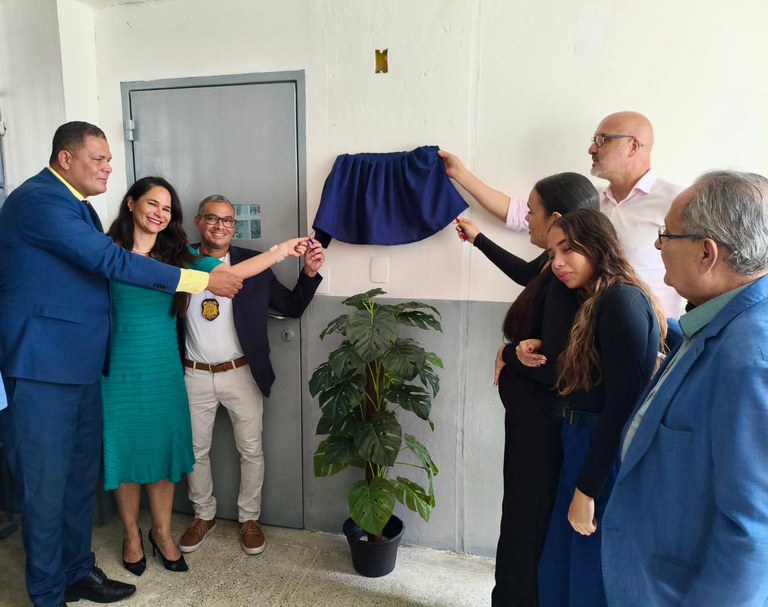 pessoas descerrando uma placa na inauguração da biblioteca
