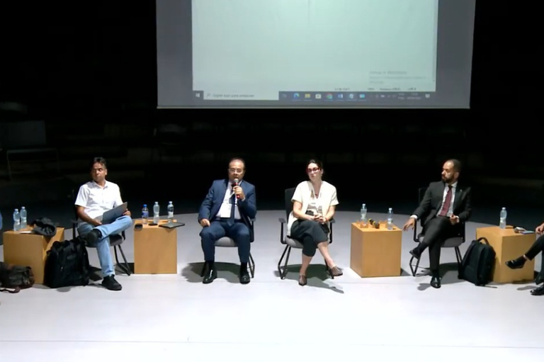 foto mostra participantes do evento em um palco