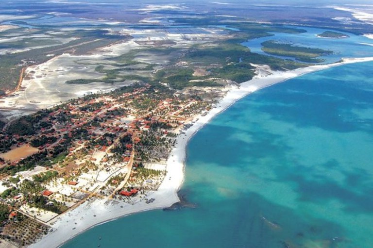 Foto aérea da orla de Cajueiro da Praia mostra o mar, com a faixa de areia e a vegetação