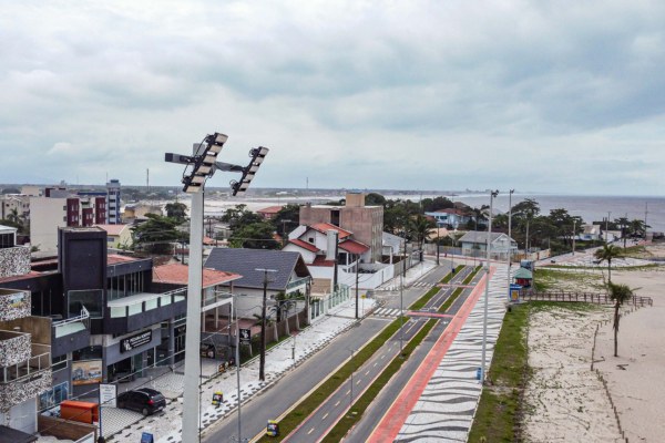 Foto aérea colorida da orla de Matinhos (PR), mostra em primeiro plano um dos 145 superpostes instalados na área.