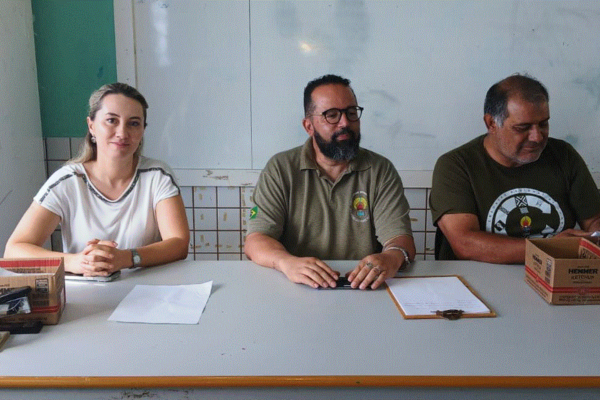 Foto colorida mostra, da esquerda para a direita, a procuradora Indira Pinheiro e os servidores da Funai William Silva Junior e Adir Veloso, sentados diante de uma mesa durante a eleição para cacique e vice-cacique na TI Mangueirinha, no Paraná