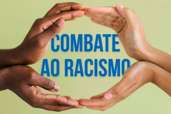 #PraTodosVerem: duas mãos com diferentes tons de pele (uma negra e outra mais clara) se unem para formar um círculo protetor ao redor do texto central "COMBATE AO RACISMO", escrito em letras azuis sobre um fundo verde claro.