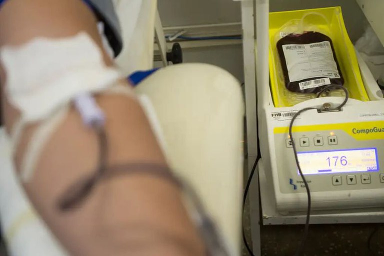 Foto mostra em detalhe uma pessoa doando sangue