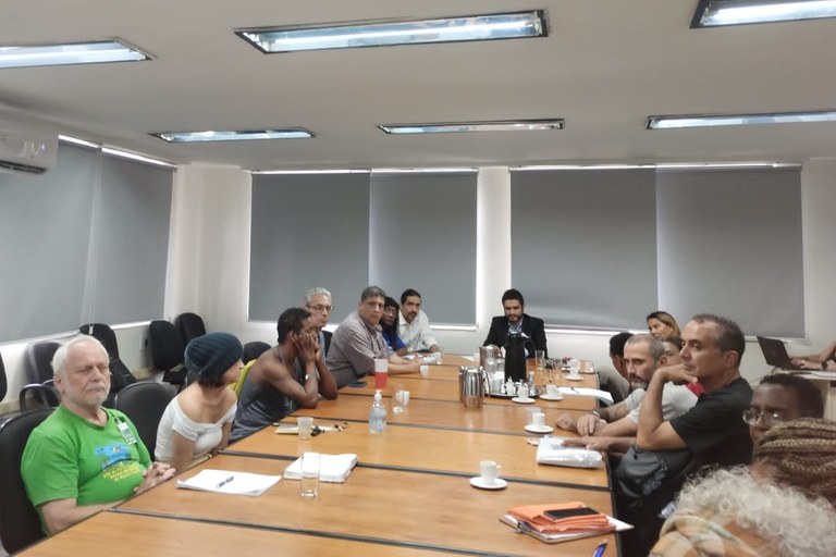 Fotogradia de uma sala com várias pessoas reunidas em volta de uma mesa grande, com o procurador da República Julio Araujo em uma das pontas. Na reunião foi criado o Fórum Permanente por Direitos da População em Situação de Rua, na sede do MPF no RJ, em 10/04/2025.