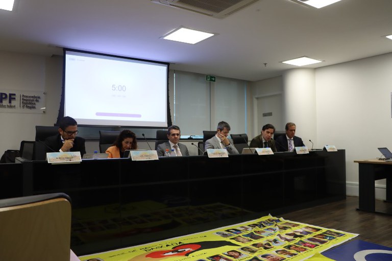 Foto mostra participantes da reunião em uma mesa