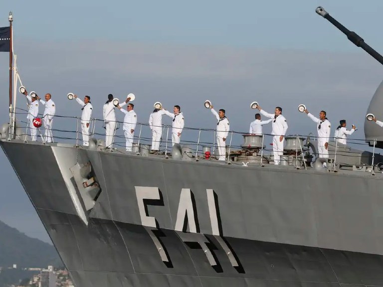Foto mostra marinheiros em navio no mar