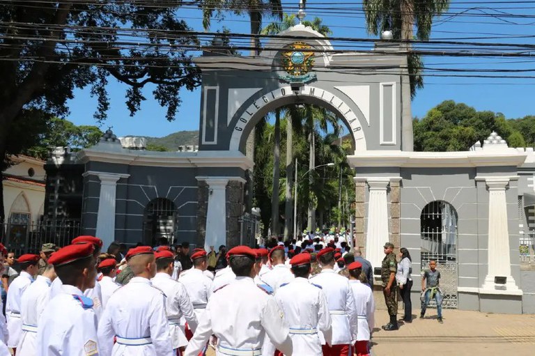 Foto mostra alunos fardados, de costas, entrando no CMRJ