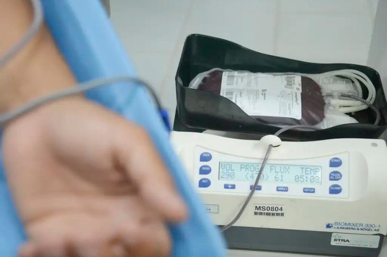 Foto mostra em detalhe um pessoa no hospital com uma bolsa de sangue