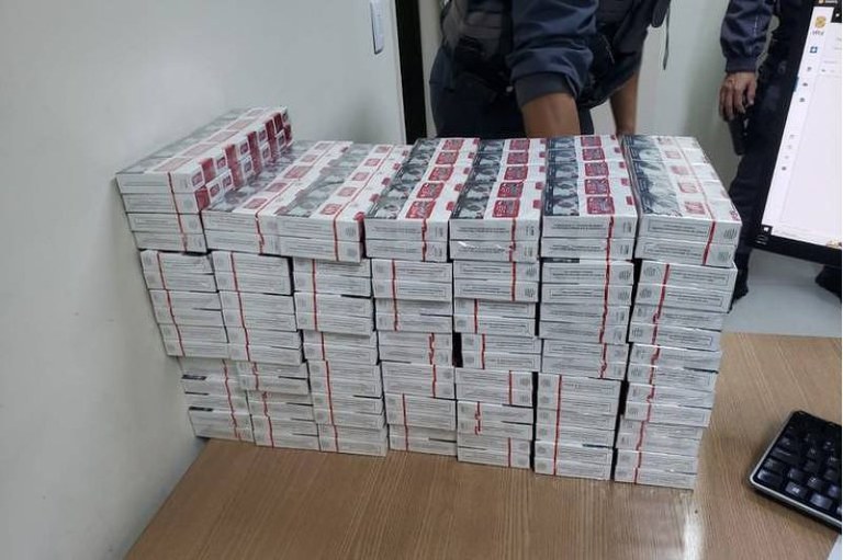 Foto mostra uma pilha de maços de cigarro