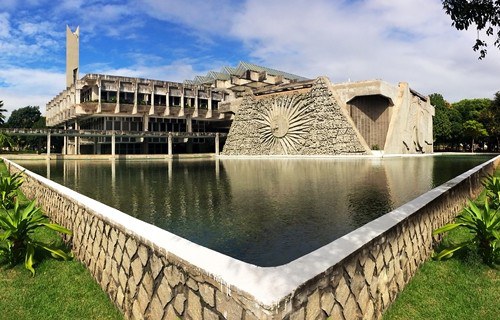Foto mostra fachada da reitoria da UFRN com um grande espelho d'água