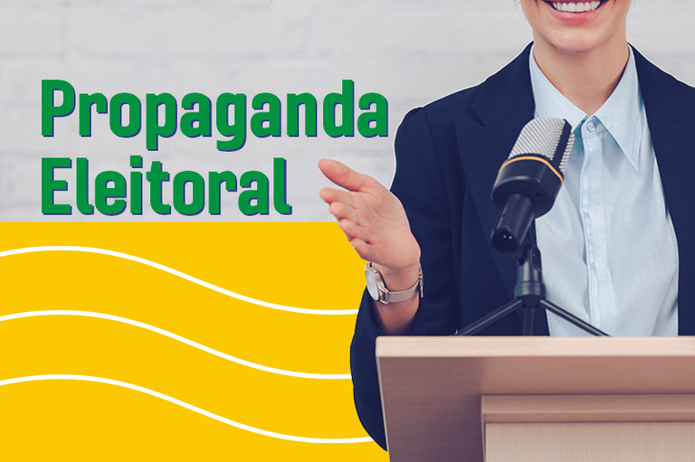 Imagem com a expressão "Propaganda Eleitoral" em letras verdes com contorno azul, posicionadas à esquerda sobre um fundo cinza que remete a uma parede de tijolos claros. Na parte inferior esquerda, há uma faixa amarela decorada com três linhas onduladas brancas na horizontal. À direita, uma mulher sorridente veste blazer azul-escuro sobre uma camisa social azul-clara; ela está posicionada atrás de um púlpito de madeira com um microfone fixado em um tripé de mesa, gesturing com a mão esquerda aberta enquanto discursa (seu rosto aparece parcialmente cortado na altura do nariz).