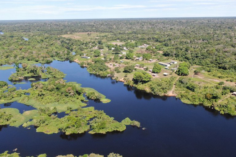 Foto aérea mostra rio e comunidades