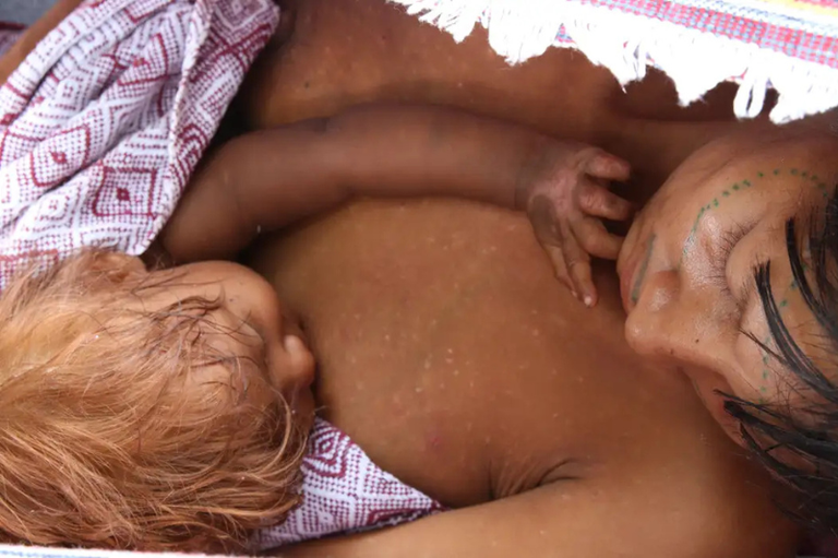 Foto de indígena com recém-nascido nos braços