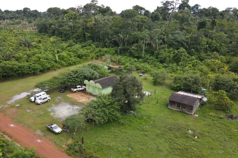 Foto  aérea da Reserva Extrativista do Ouro Preto mostra a vegetação, carros e casas