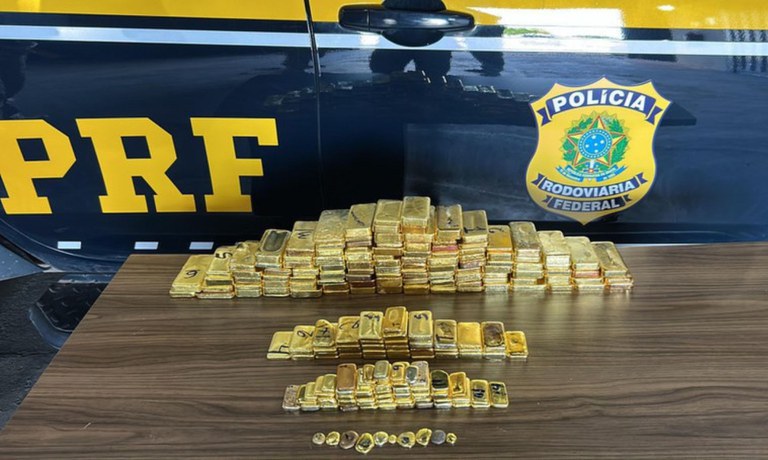 Foto mostra barras de ouro em cima do capô de um carro da PRF