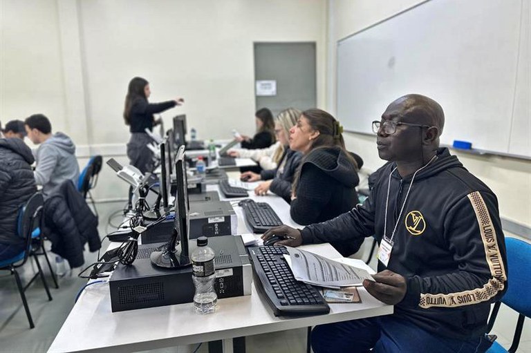 Foto mostra servidores públicos atendendo migrantes na UPF