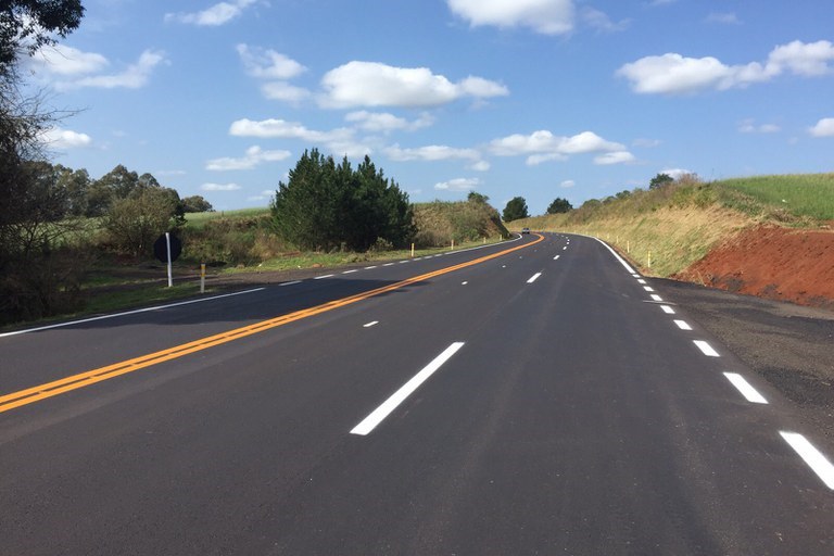 Dotografia da rodovia BR-285, no trecho entre em Passo Fundo (RS) e Carazinho (RS). Rodovia asfaltada com vegetação em ambos os lados e o céu azul com poucas nuvens.