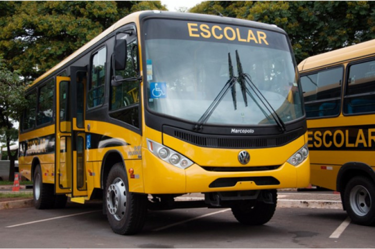 ônibus amarelo escrito transporte escolar estacionado na rua