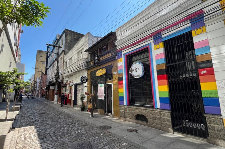 Fotografia de uma rua de paparelepípedos com casas antigas, algumas coloridas