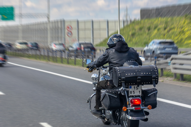 Foto mostra motociclista pilotando em uma rodovia