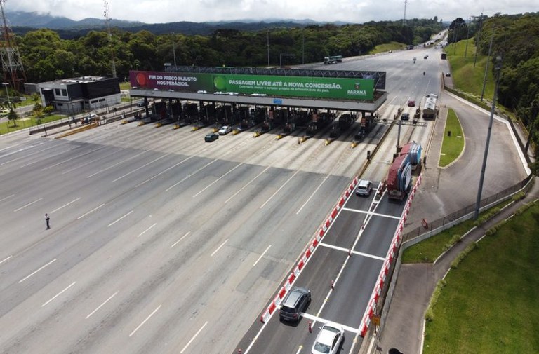Foto mostra carros chegando a uma estação de pedágio