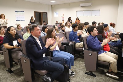 A plateia de um auditório bate palmas.
